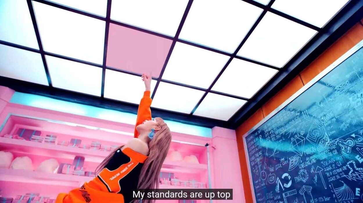 Lisa pointing up at the pink square tile, as in SQUARE UP the album